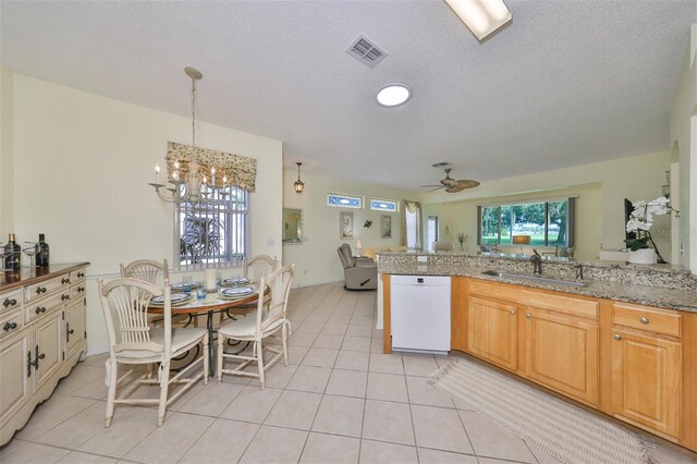 kitchen with a textured ceiling, ceiling fan with notable chandelier, white dishwasher, and light tile patterned floors