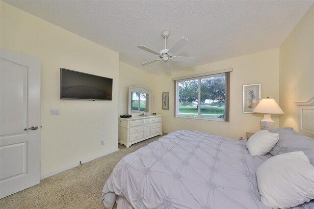 carpeted bedroom featuring a textured ceiling and ceiling fan