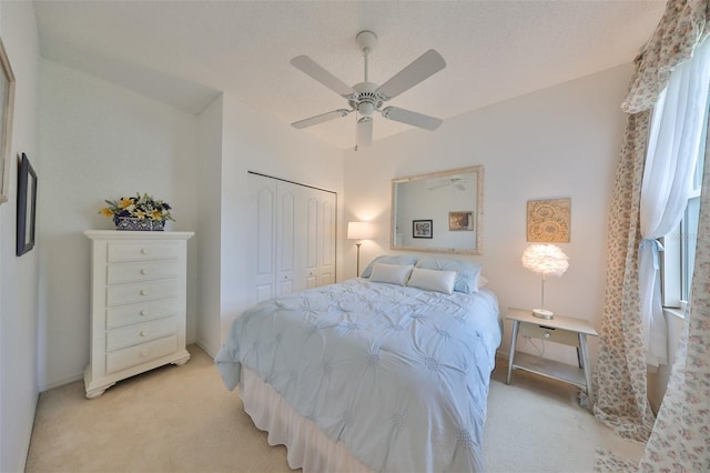 carpeted bedroom featuring ceiling fan and a closet