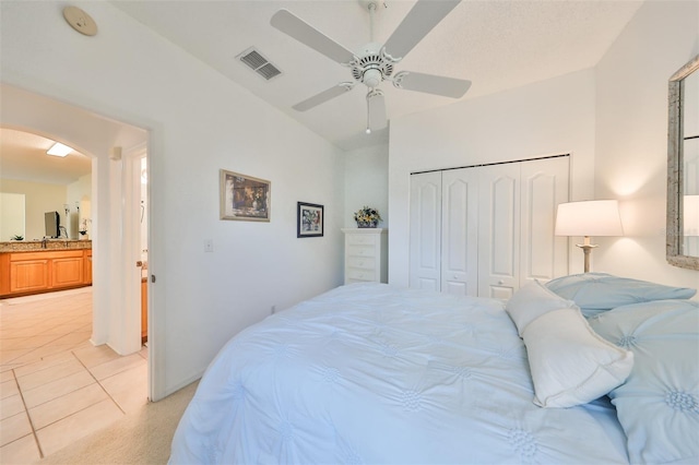 tiled bedroom featuring ceiling fan, a closet, and sink