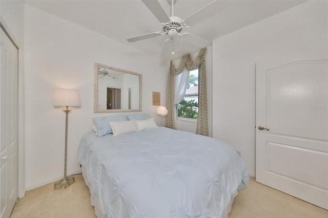 carpeted bedroom featuring ceiling fan and a closet