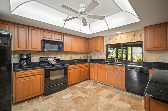 kitchen with ceiling fan, sink, tasteful backsplash, dark stone counters, and black appliances