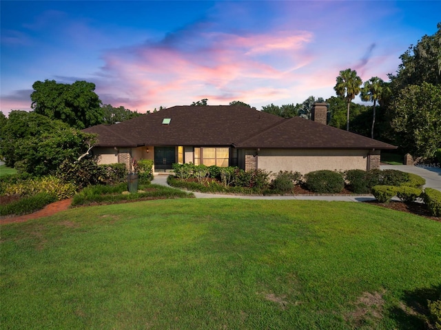 ranch-style home with a lawn