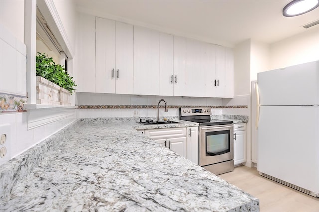 kitchen with stainless steel range with electric stovetop, sink, light wood-type flooring, white cabinets, and white refrigerator