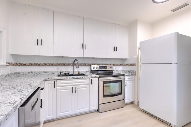 kitchen with sink, light hardwood / wood-style flooring, decorative backsplash, white cabinetry, and stainless steel appliances