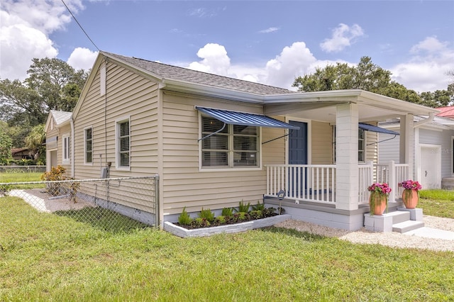 view of front of property featuring a garage, a front yard, and covered porch