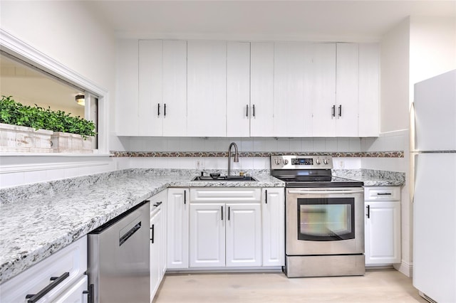 kitchen featuring light hardwood / wood-style floors, sink, stainless steel appliances, and white cabinetry