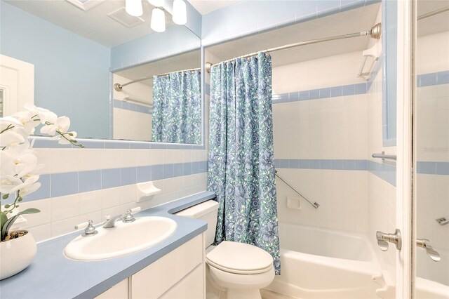 full bathroom with backsplash, toilet, shower / bath combo with shower curtain, vanity, and tile walls