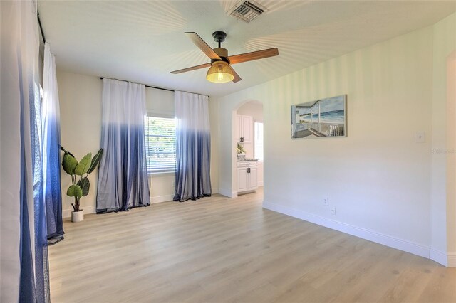 unfurnished room with light wood-type flooring and ceiling fan