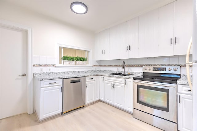 kitchen featuring sink, light wood-type flooring, white cabinets, and appliances with stainless steel finishes