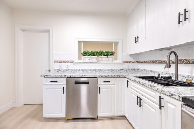 kitchen with decorative backsplash, light hardwood / wood-style flooring, light stone counters, dishwasher, and sink