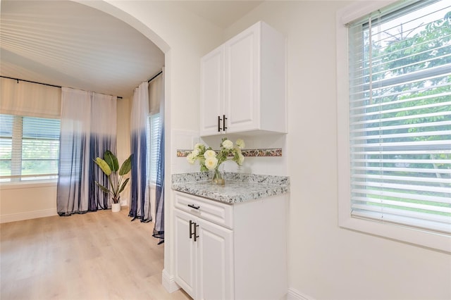 kitchen featuring light hardwood / wood-style flooring, a healthy amount of sunlight, and light stone countertops