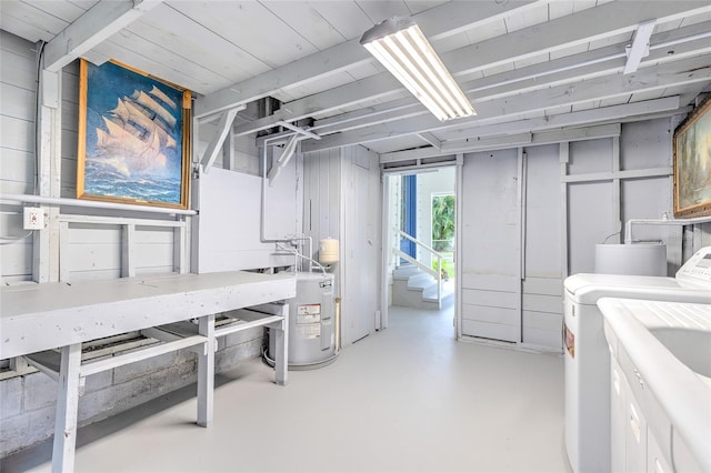 basement featuring washing machine and dryer, sink, and electric water heater