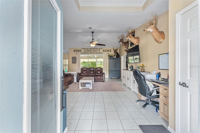 carpeted home office with ceiling fan, a raised ceiling, and a textured ceiling