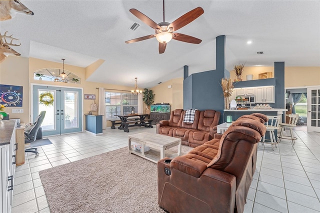 tiled living room featuring ceiling fan with notable chandelier, french doors, a textured ceiling, and high vaulted ceiling