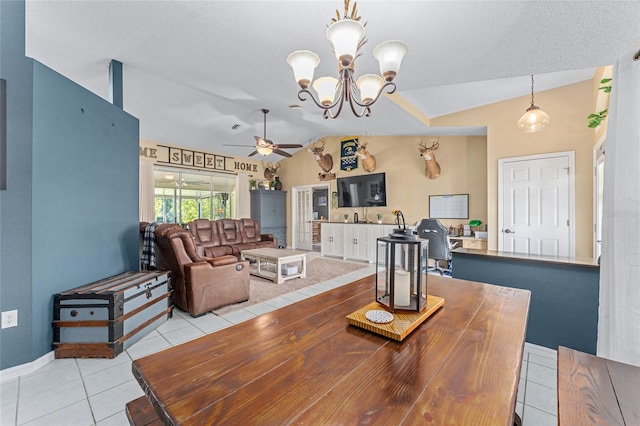 tiled dining space with lofted ceiling, ceiling fan with notable chandelier, and a textured ceiling