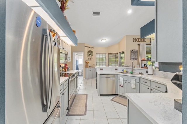 kitchen with gray cabinetry, a wealth of natural light, sink, and appliances with stainless steel finishes