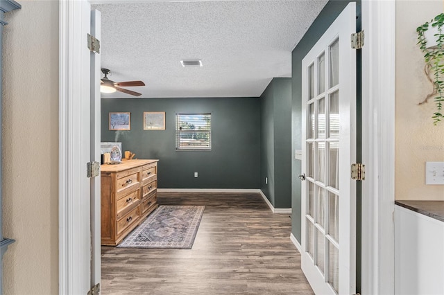 interior space featuring dark hardwood / wood-style flooring, ceiling fan, and a textured ceiling