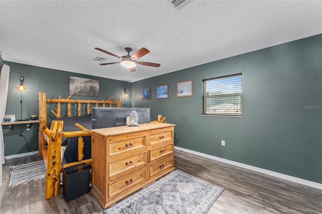 bedroom featuring dark wood-type flooring, a textured ceiling, and ceiling fan