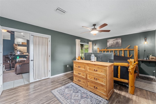 bedroom featuring vaulted ceiling, dark hardwood / wood-style flooring, ceiling fan, and a textured ceiling