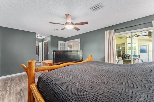 bedroom featuring a textured ceiling, hardwood / wood-style floors, and ceiling fan