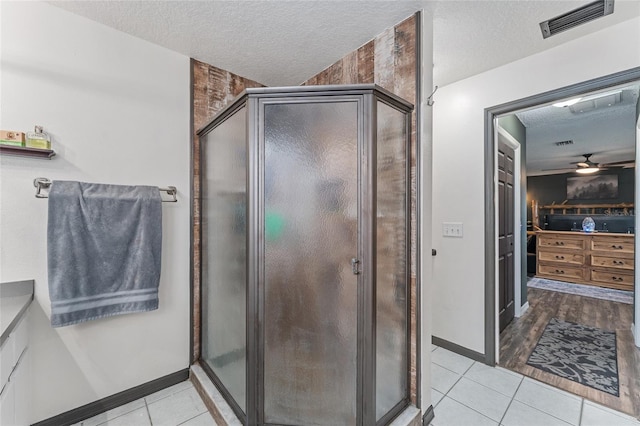 bathroom featuring a textured ceiling, vanity, walk in shower, hardwood / wood-style flooring, and ceiling fan