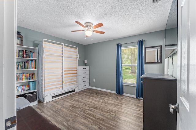 unfurnished office featuring dark hardwood / wood-style flooring, ceiling fan, and a textured ceiling