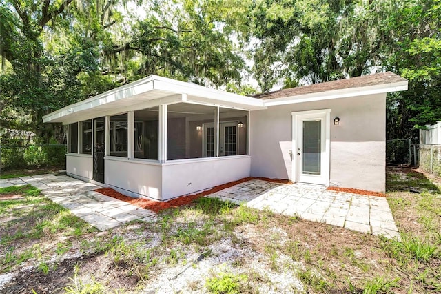 rear view of house featuring a sunroom and a patio area