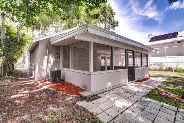 view of side of property featuring central air condition unit and a sunroom