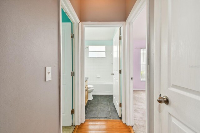 corridor with plenty of natural light and tile patterned floors