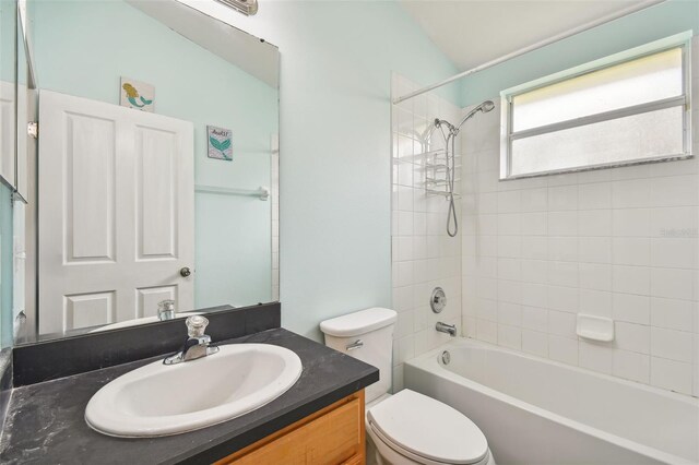 full bathroom featuring toilet, tiled shower / bath combo, and vanity