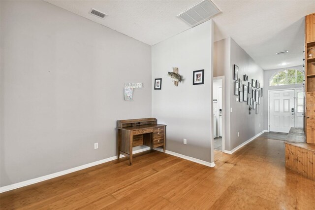 hall with hardwood / wood-style flooring and a textured ceiling