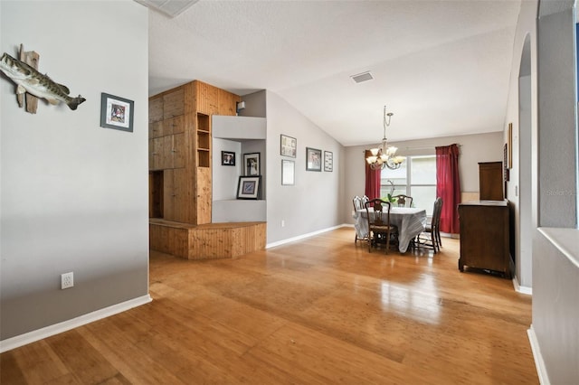 6843 Runner Oak Dr, Wesley Chapel, FL 33545 - unfurnished dining area featuring light wood finished floors, visible vents, an inviting chandelier, vaulted ceiling, and baseboards