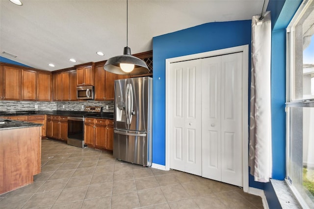 6843 Runner Oak Dr, Wesley Chapel, FL 33545 - kitchen with stainless steel appliances, tasteful backsplash, dark countertops, and decorative light fixtures