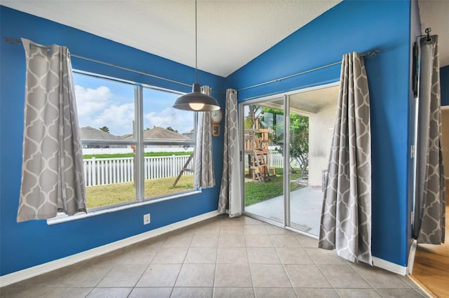 doorway to outside with lofted ceiling and light tile patterned floors