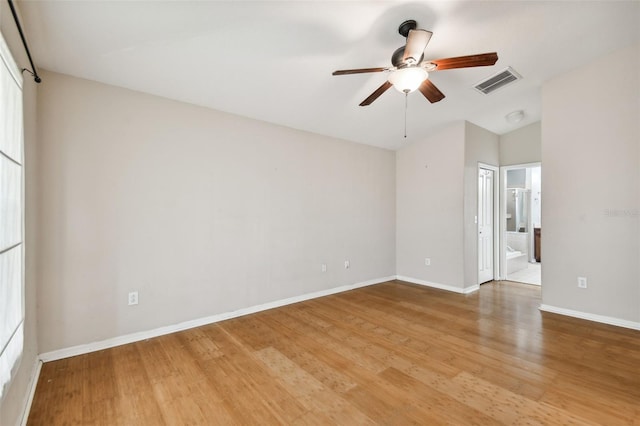 empty room featuring ceiling fan, light wood-type flooring, and vaulted ceiling