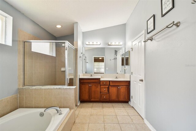 bathroom with lofted ceiling, shower with separate bathtub, vanity, and tile patterned floors