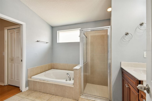 bathroom with plus walk in shower, tile patterned flooring, a textured ceiling, and vanity