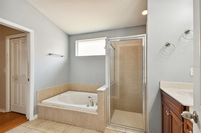 6843 Runner Oak Dr, Wesley Chapel, FL 33545 - bathroom with a textured ceiling, a garden tub, vanity, tile patterned floors, and a stall shower