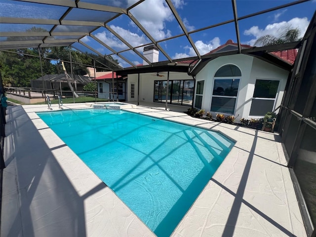 view of swimming pool featuring a lanai, a patio area, and an in ground hot tub