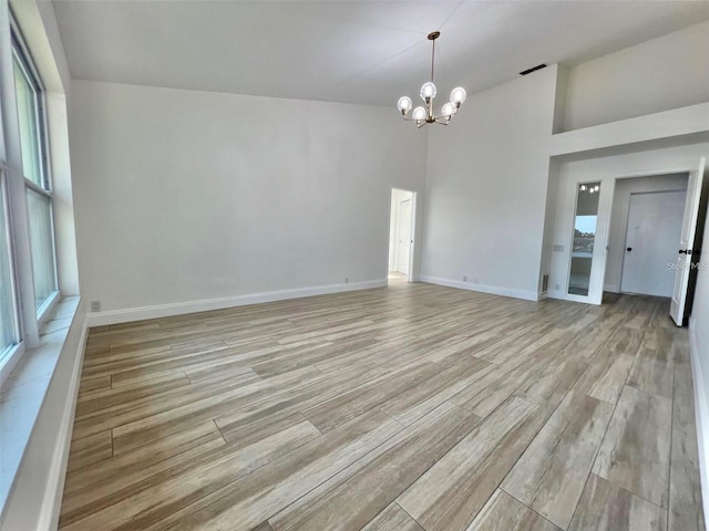 empty room featuring a high ceiling and a notable chandelier