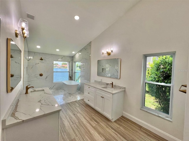 bathroom with vanity, lofted ceiling, and plus walk in shower