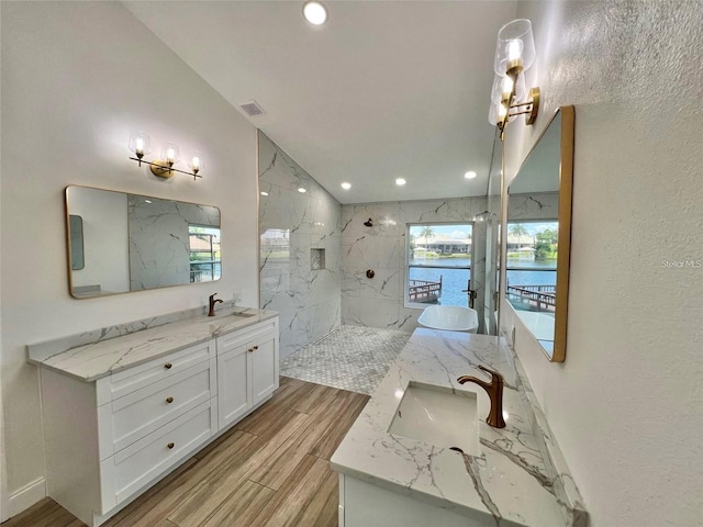 bathroom with lofted ceiling, a water view, vanity, and tiled shower