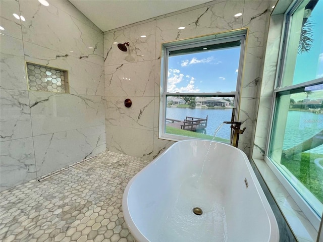 bathroom featuring a bathing tub and a water view