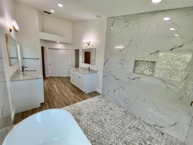 bathroom with vanity, a washtub, and hardwood / wood-style floors