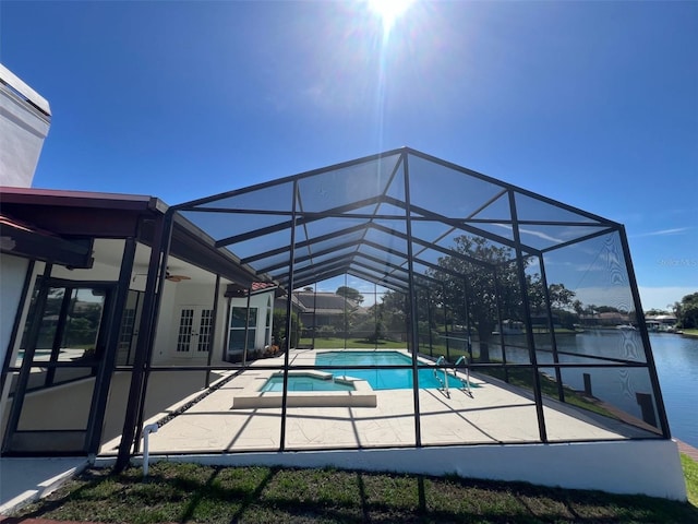 view of swimming pool featuring a water view, ceiling fan, a patio, and glass enclosure