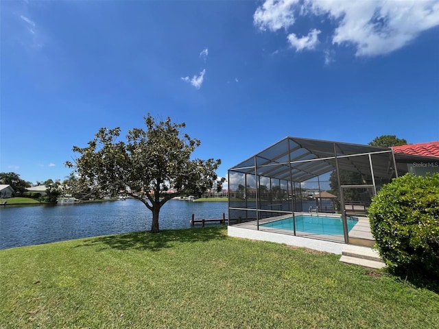 view of swimming pool featuring glass enclosure, a lawn, and a water view