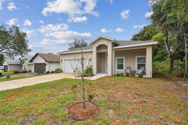 view of front of home with a garage, concrete driveway, a front yard, and stucco siding