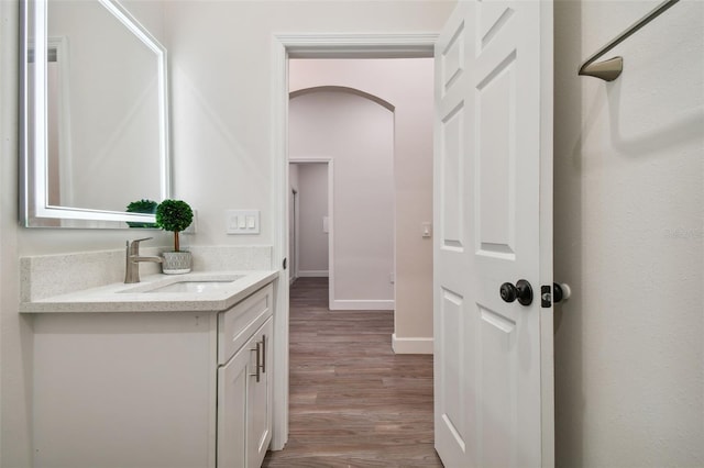 bathroom featuring wood finished floors, vanity, and baseboards