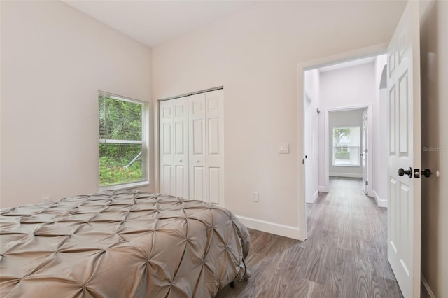 unfurnished bedroom featuring a closet, baseboards, and wood finished floors